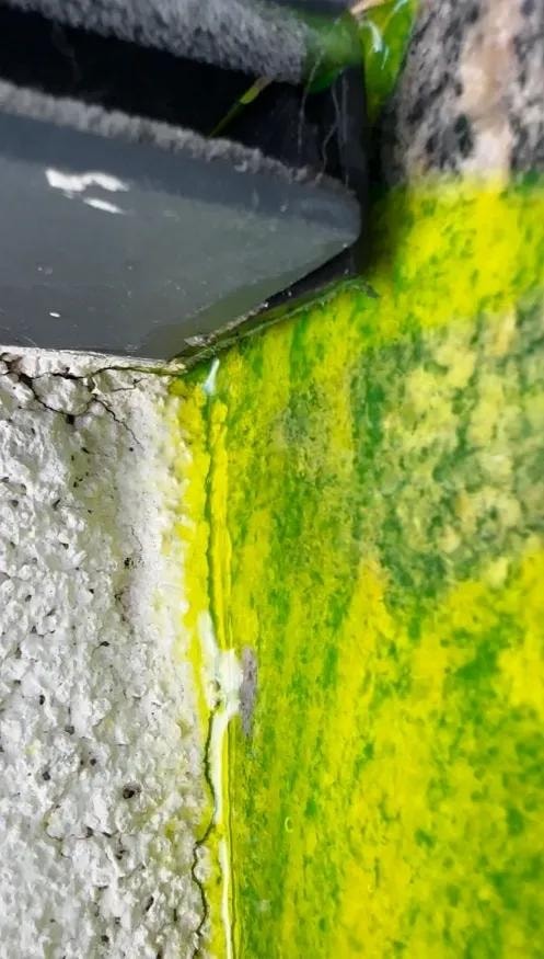 Detalj mermerne okapnice sa fluorescentnom bojom koja curi