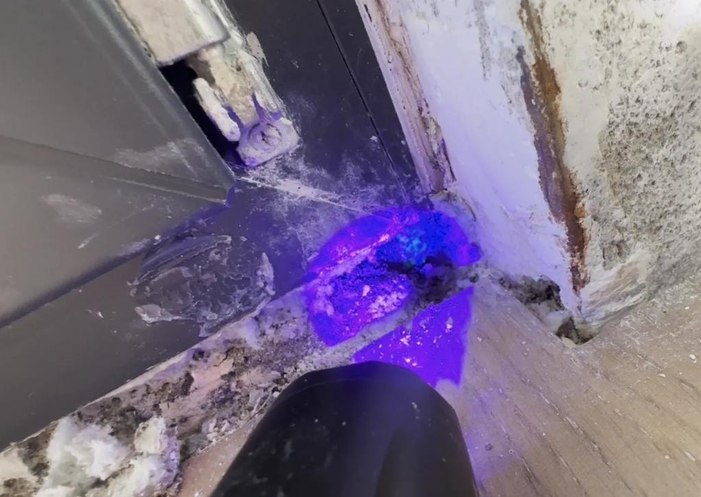 UV lampa otkriva fluorescentnu boju u uglu spoja stolarije i zida